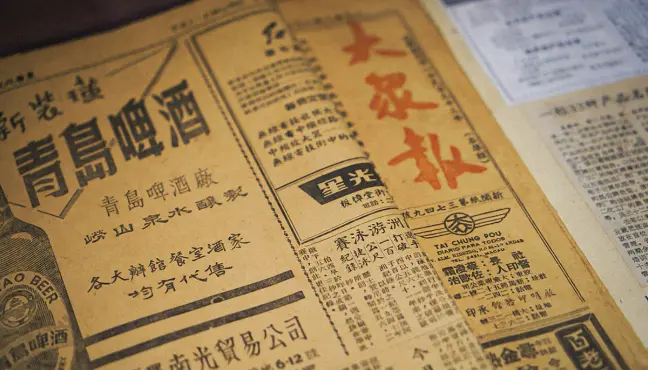 Aged newspaper page with Chinese text and printed ads.