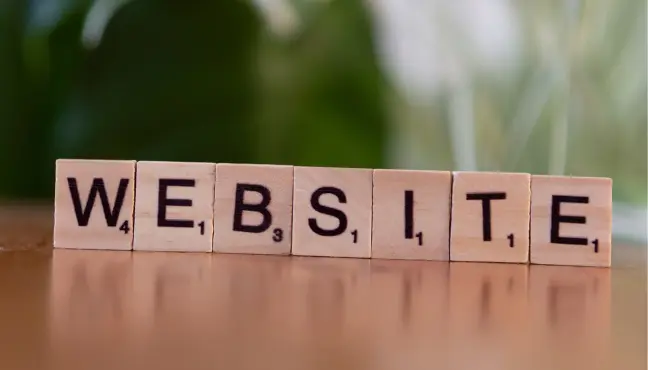 Wooden letter tiles spelling 'WEBSITE' on a desk